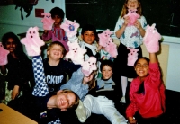 Children holding furry, pink puppets in the air C.1986/87