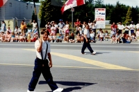 Boys walking in parade holding Canadian flag