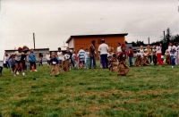 Potato-sack racers and onlookers, all wearing blue ribbons C.1987/88