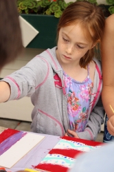 A child painting her tic-tac-toe board