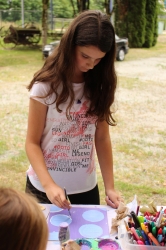 A child painting her tic-tac-toe board from the first week of Heritage Thursday