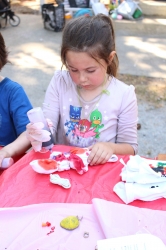 A child working on her tie-dye shirt.