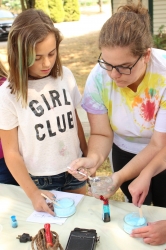 Museum Assistant Keagan assisting a child with making her putty