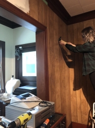 Photo of summer student removing nails from the walls before painting